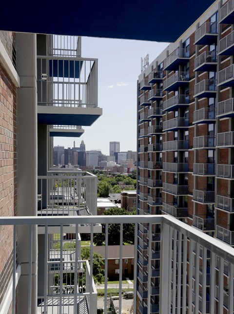 A tall building with a balcony overlooking a city skyline.