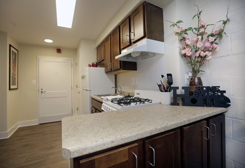 A kitchen with a white stove top oven and a white refrigerator.