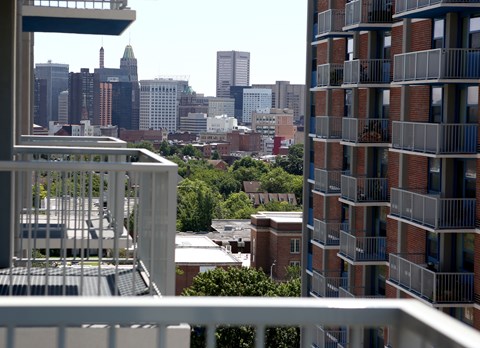 A cityscape is seen from a balcony.