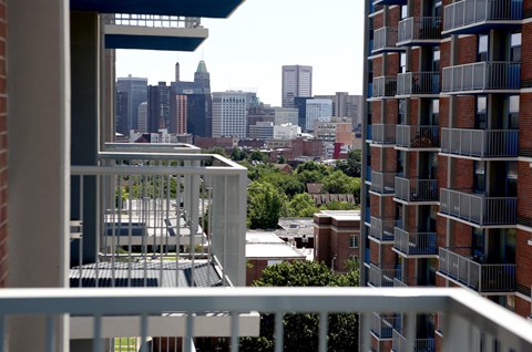 A cityscape is visible from a balcony.