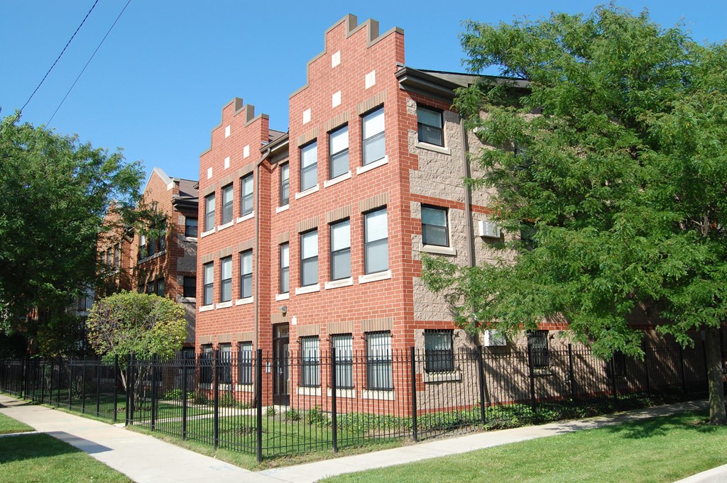 a large brick building with a black fence in front of it