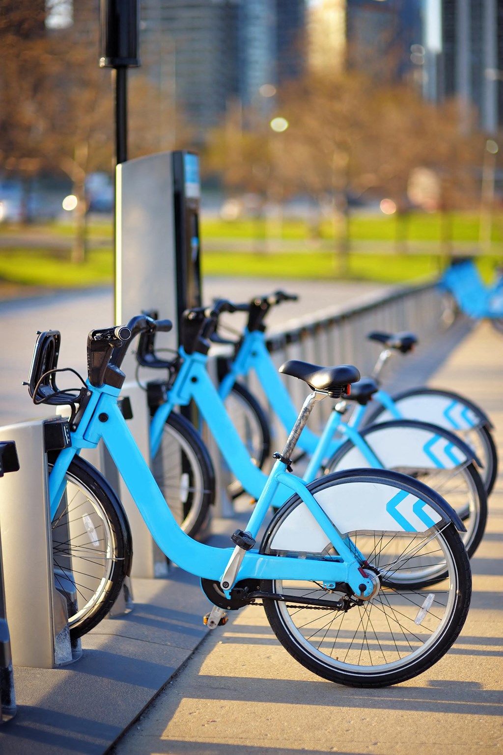 a row of blue bikes parked next to a pole