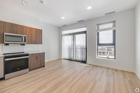 A spacious kitchen with wooden cabinets and a microwave above the stove.