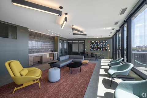 A modern living room with a yellow chair and a grey couch.