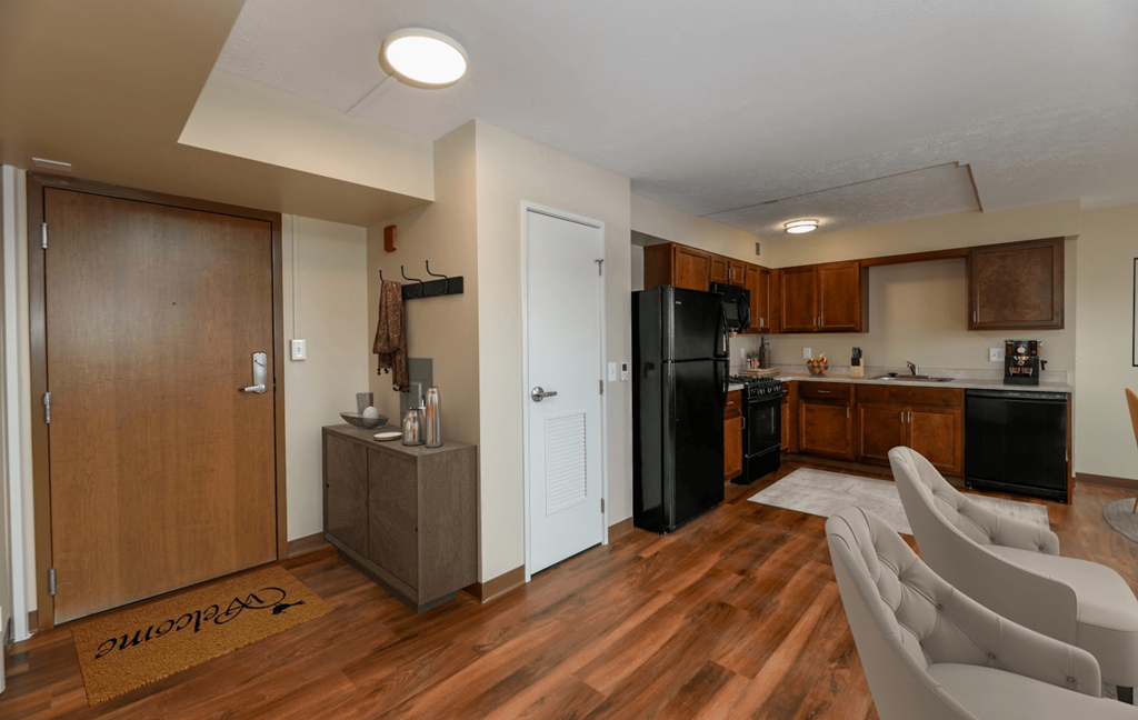 A kitchen with a refrigerator, sink, and cabinets.