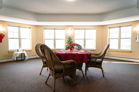 A dining room with a table set for a Christmas dinner.
