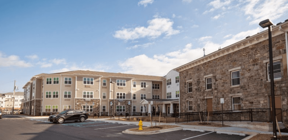 an image of an apartment building with a car parked in front of it