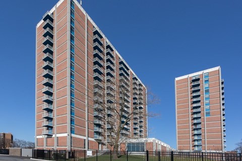 A tall red brick building with balconies on the side.