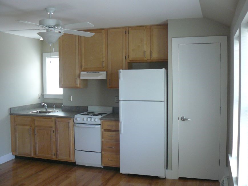A kitchen with wooden cabinets and a white refrigerator.