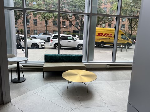 A view of a street through a window with a DHL van on it.