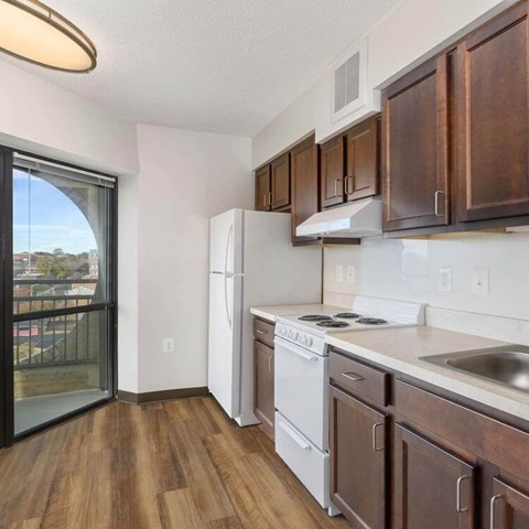 A kitchen with wooden cabinets and a white fridge.