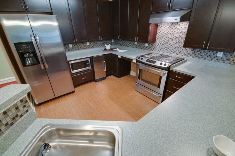 a kitchen with stainless steel appliances and wooden floors