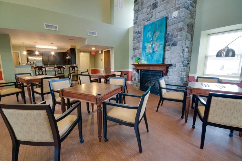 a dining room with tables and chairs and a stone fireplace