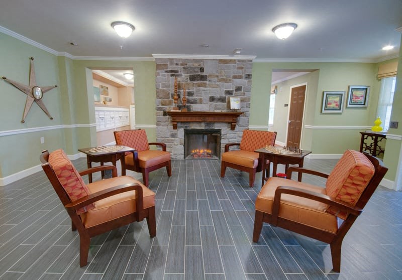 a living room with chairs and a fireplace