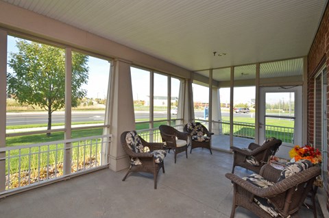 A sunroom with a white ceiling and a view of the street outside.