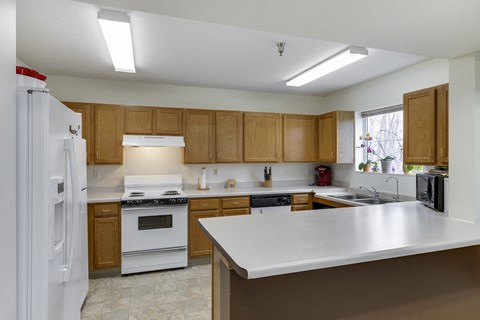 A kitchen with white appliances and wooden cabinets.