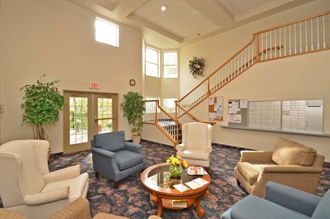 A living room with a staircase and a calendar on the wall.