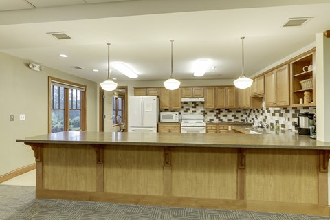 A kitchen with wooden cabinets and a large island.