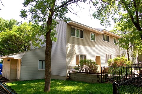 A house with a grey siding and a brown door.