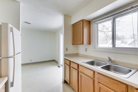 A kitchen with wooden cabinets and a white sink.