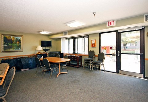 A conference room with a table, chairs, and a painting on the wall.