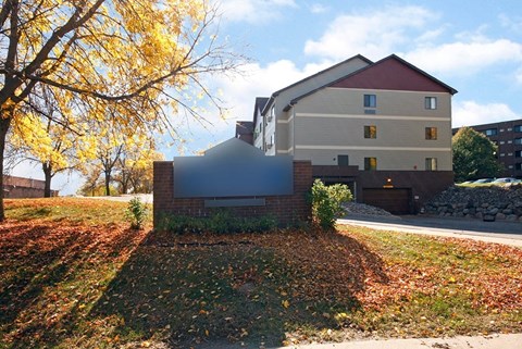 A house with a red roof and a tree with yellow leaves in front.