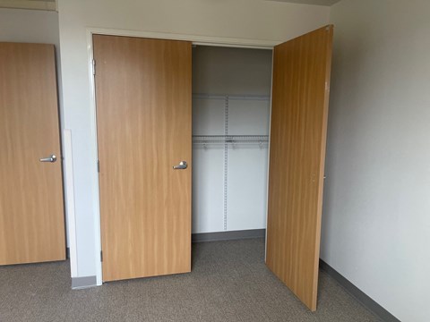 Three brown doors in a white room.