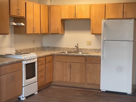 A kitchen with wooden cabinets and a white refrigerator.