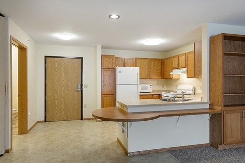 A kitchen with a white refrigerator and wooden cabinets.