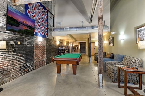 A room with a pool table and a couch.