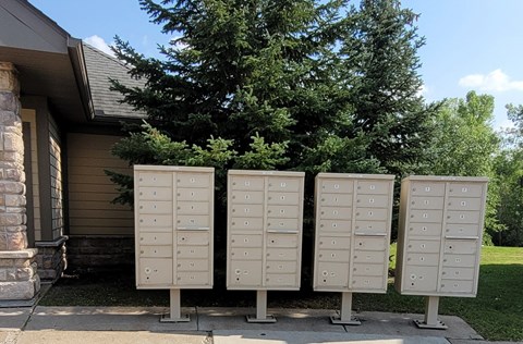 Four mailboxes are lined up in front of a house.