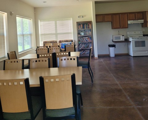 A kitchen with a dining table and chairs.