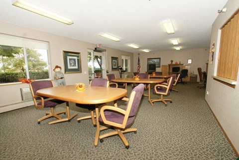 A conference room with a table surrounded by chairs.