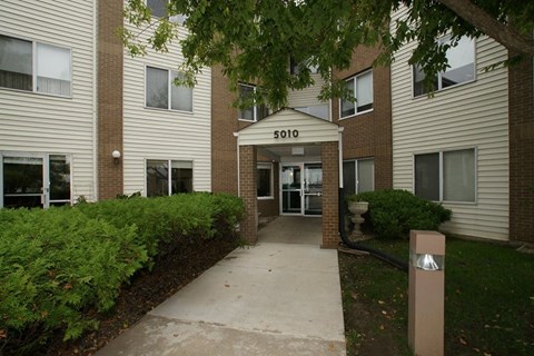 The image shows the front of apartment building number 5010 with a walkway leading to the entrance.