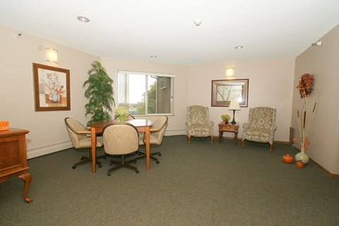 A room with a table and chairs and a potted plant.