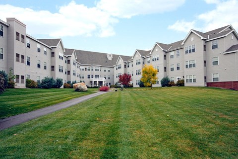 A large grassy area in front of apartment buildings.