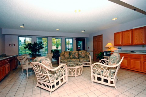 A living room with white furniture and a large window.