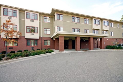 A large apartment complex with a parking lot in front.