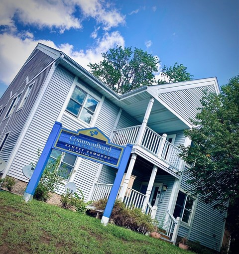 A blue and white house with a sign that says "Common Bond" on it.