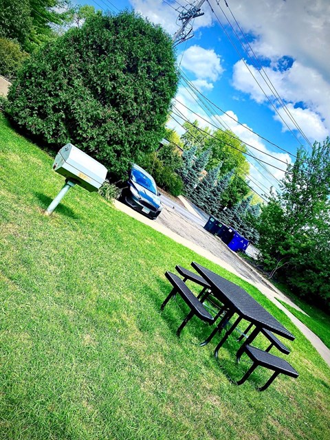 A picnic table is in the foreground of a grassy area.
