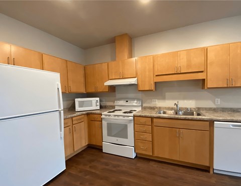 A kitchen with wooden cabinets and white appliances.