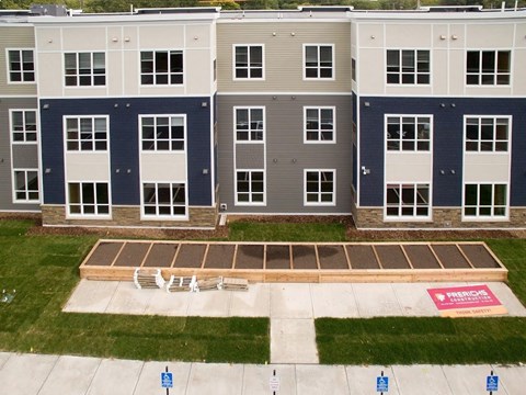 Apartment complex with a pool in the front.
