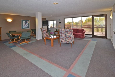 A living room with a couch, chairs, and a television.