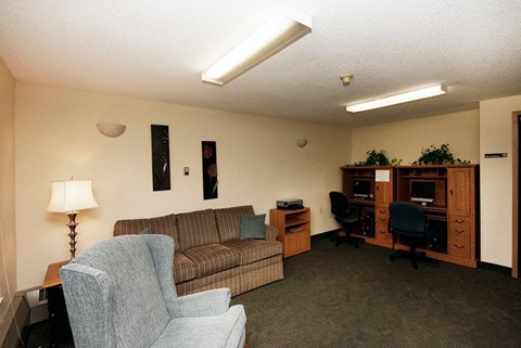 A living room with a couch, chair, and desk.