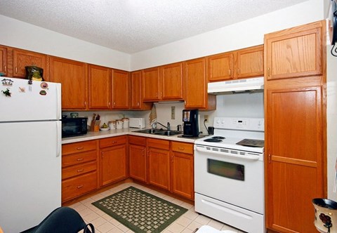 A kitchen with wooden cabinets and a white refrigerator.