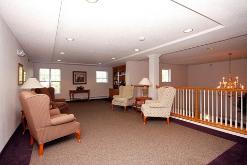 A living room with a couch, chairs, and a balcony.