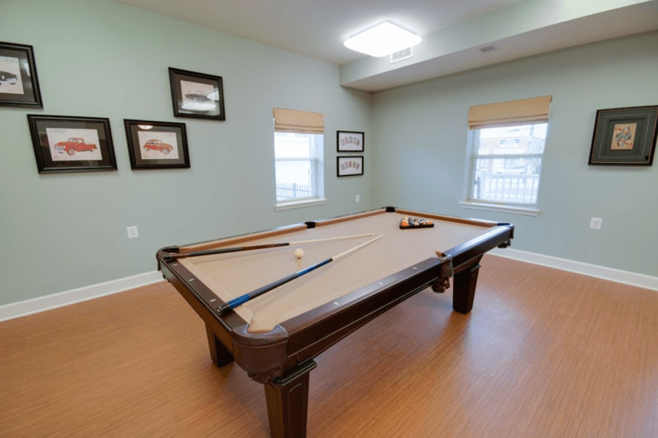 a game room with a pool table and two windows