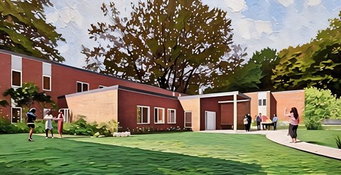 A red building with a green lawn in front.