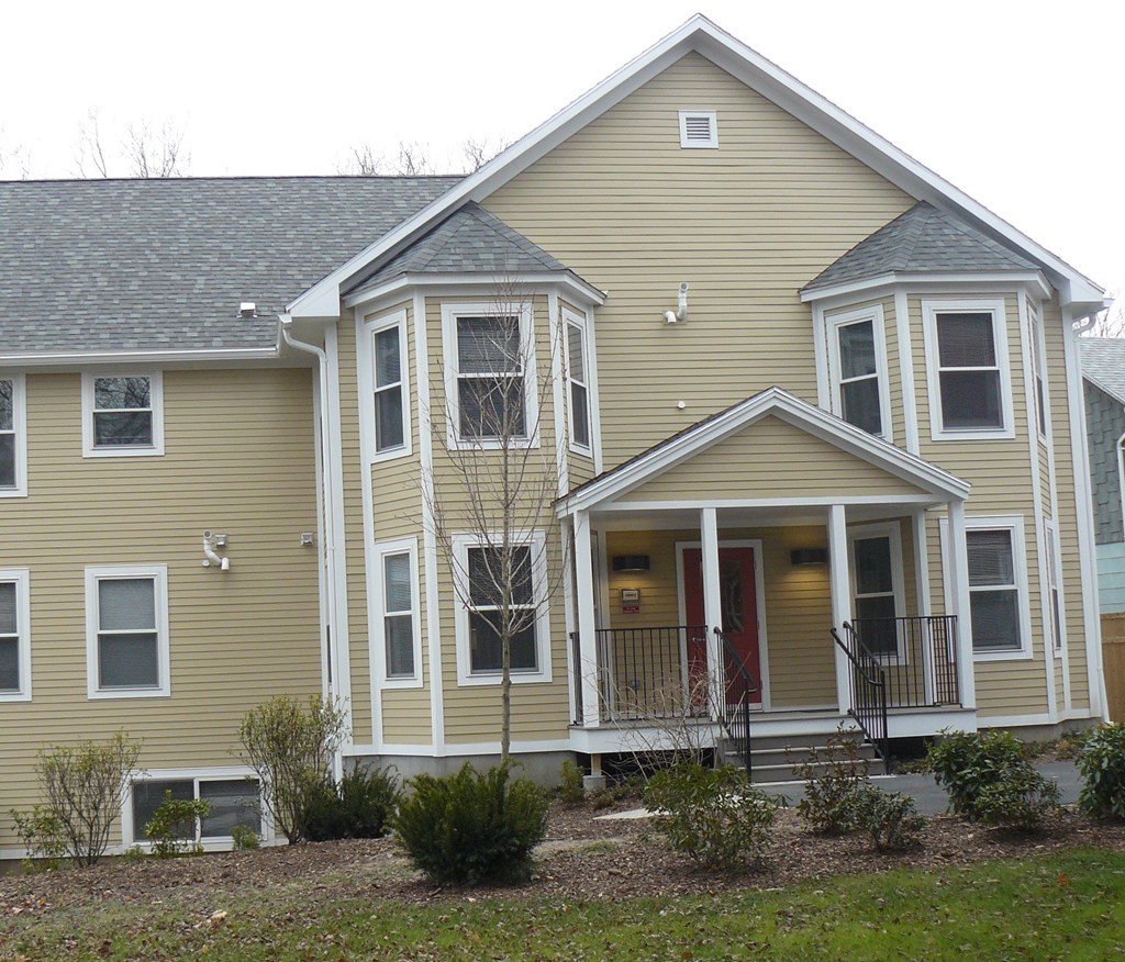A two-story house with a red door and white trim.