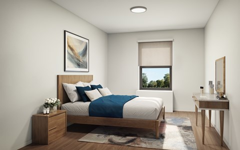 A bedroom with a bed, nightstand, and a window with a view of trees.